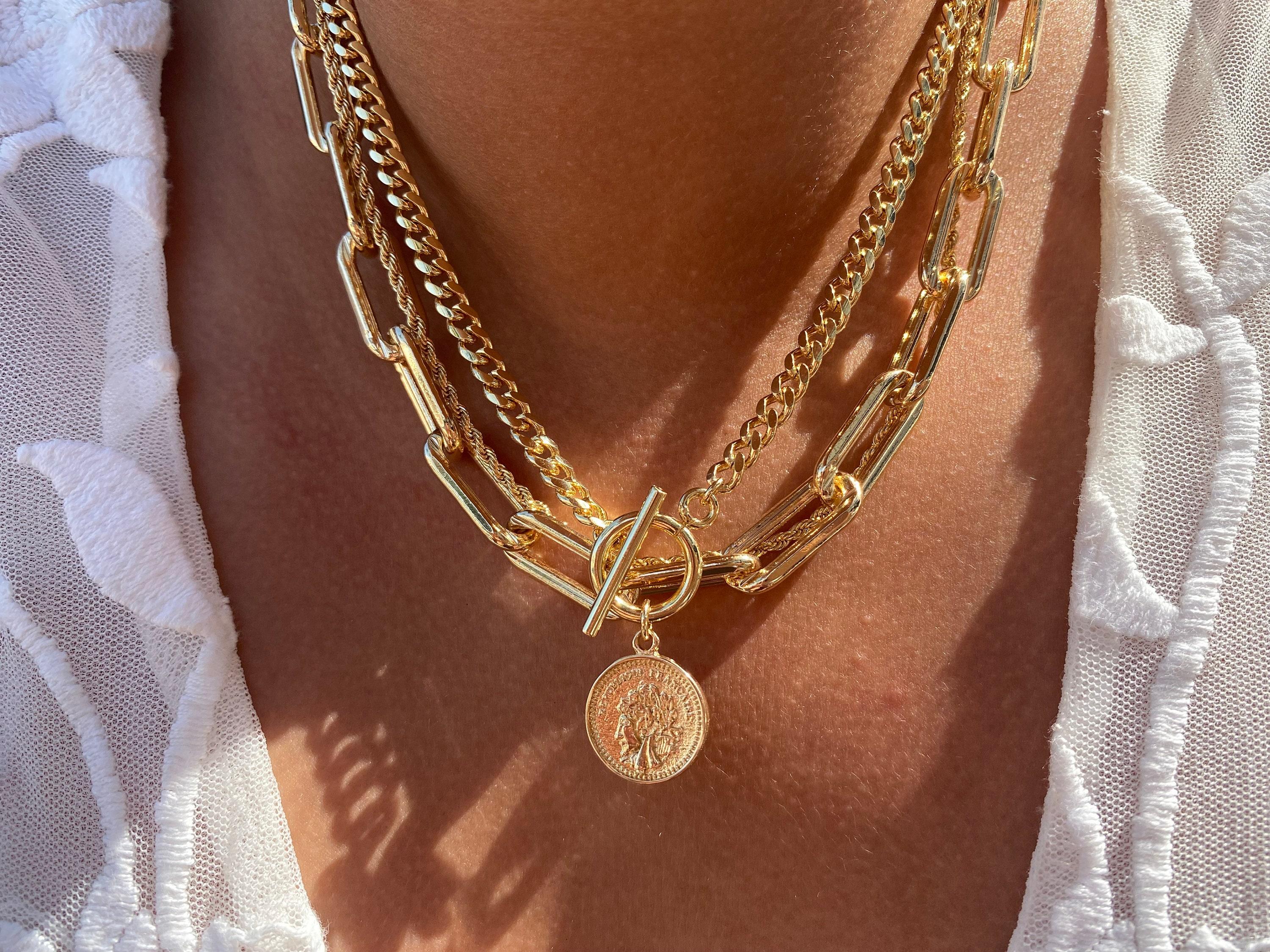 1) Subtle Elegance: Start your layered chain journey with delicate gold or silver pieces that whisper sophistication. Opt for thin, minimalist chains adorned with small pendants or charms. This understated approach adds a touch of refinement to any outfit, perfect for both casual brunch dates and office attire