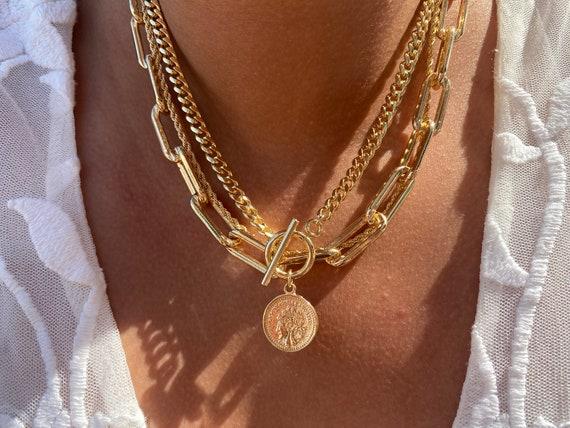 4) Savage Glam: Go bold with oversized chains and dramatic accents. Think thick gold or silver links adorned with spikes and gemstones for a fierce look that commands attention. Pair with a simple outfit to let the accessories take center stage, making your layered chains the ultimate statement piece in any ensemble